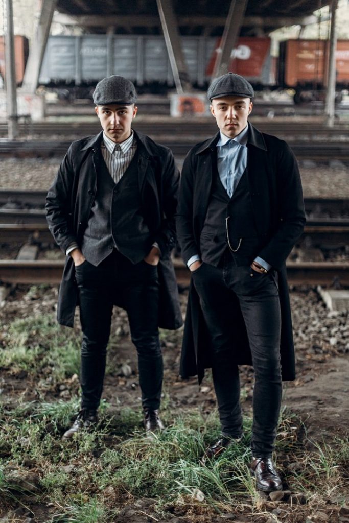 Stylish gangsters men, posing on background of railway